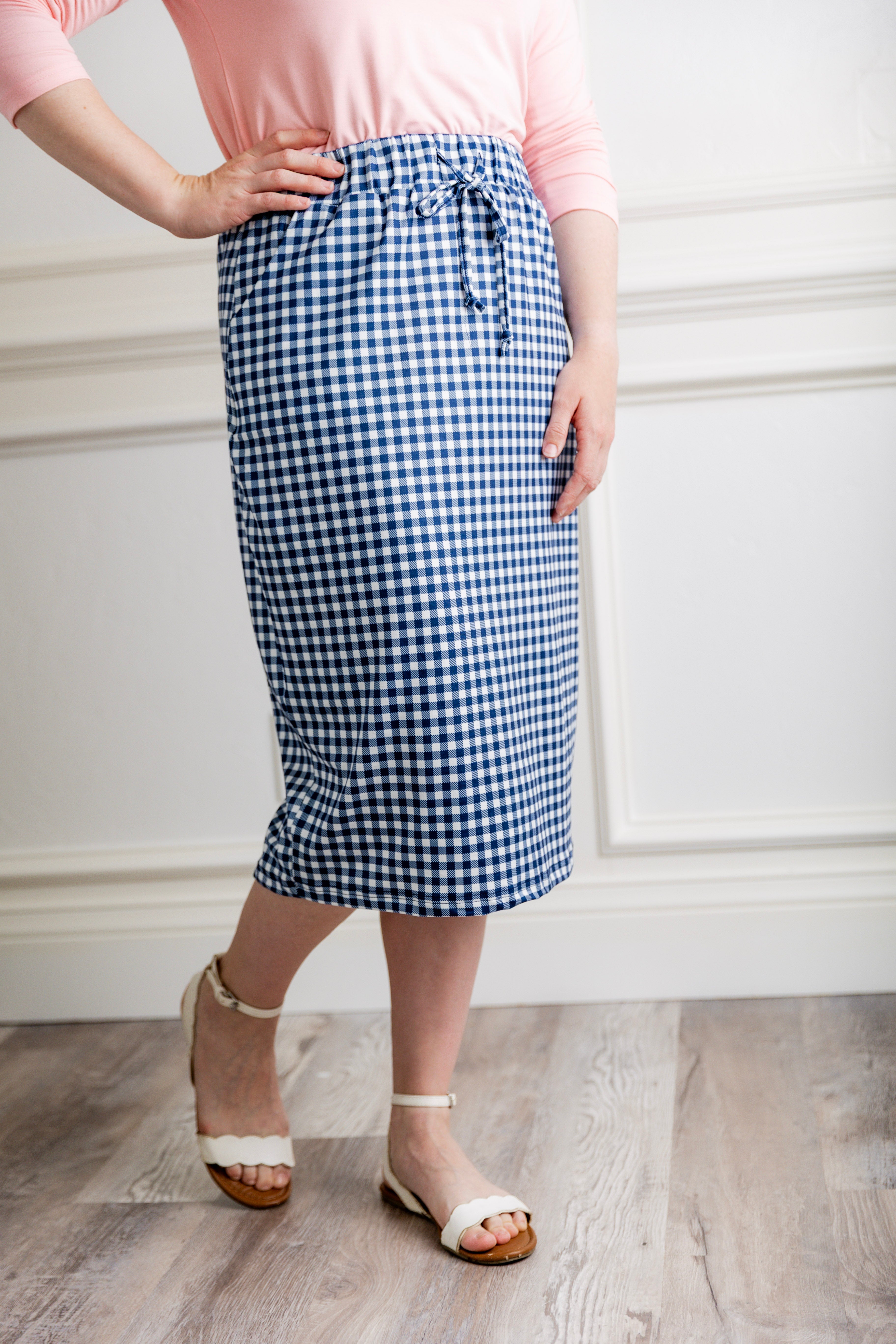 Woman in a modest 27-inch blue gingham knit skirt featuring side pockets and a drawstring waistband.