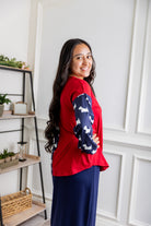 Model wearing the Nuggles® Harlow Top with red and navy color block design.