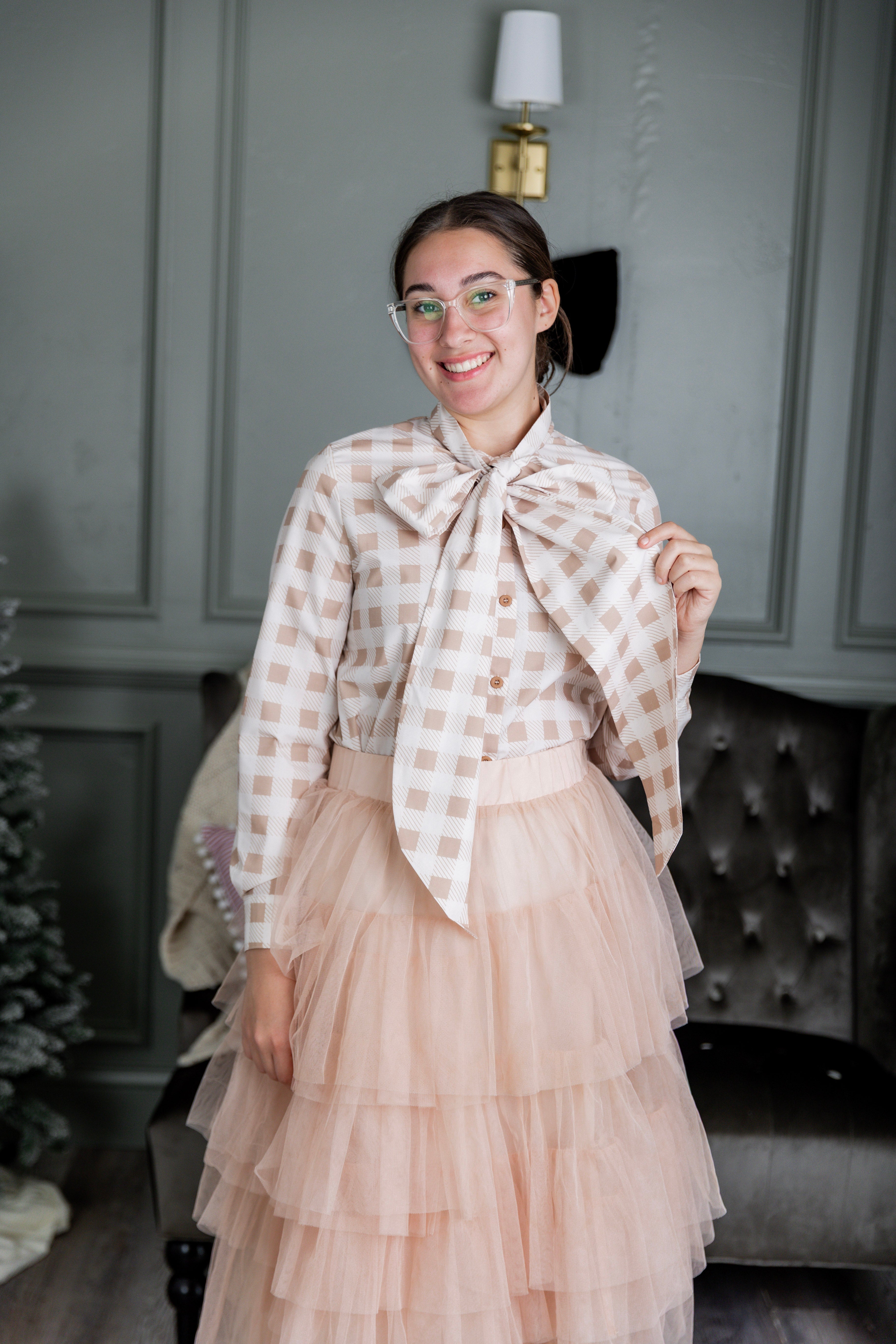 Model wearing Nuggles® Felicity top with large bow tie neckline, modest women's blouse.