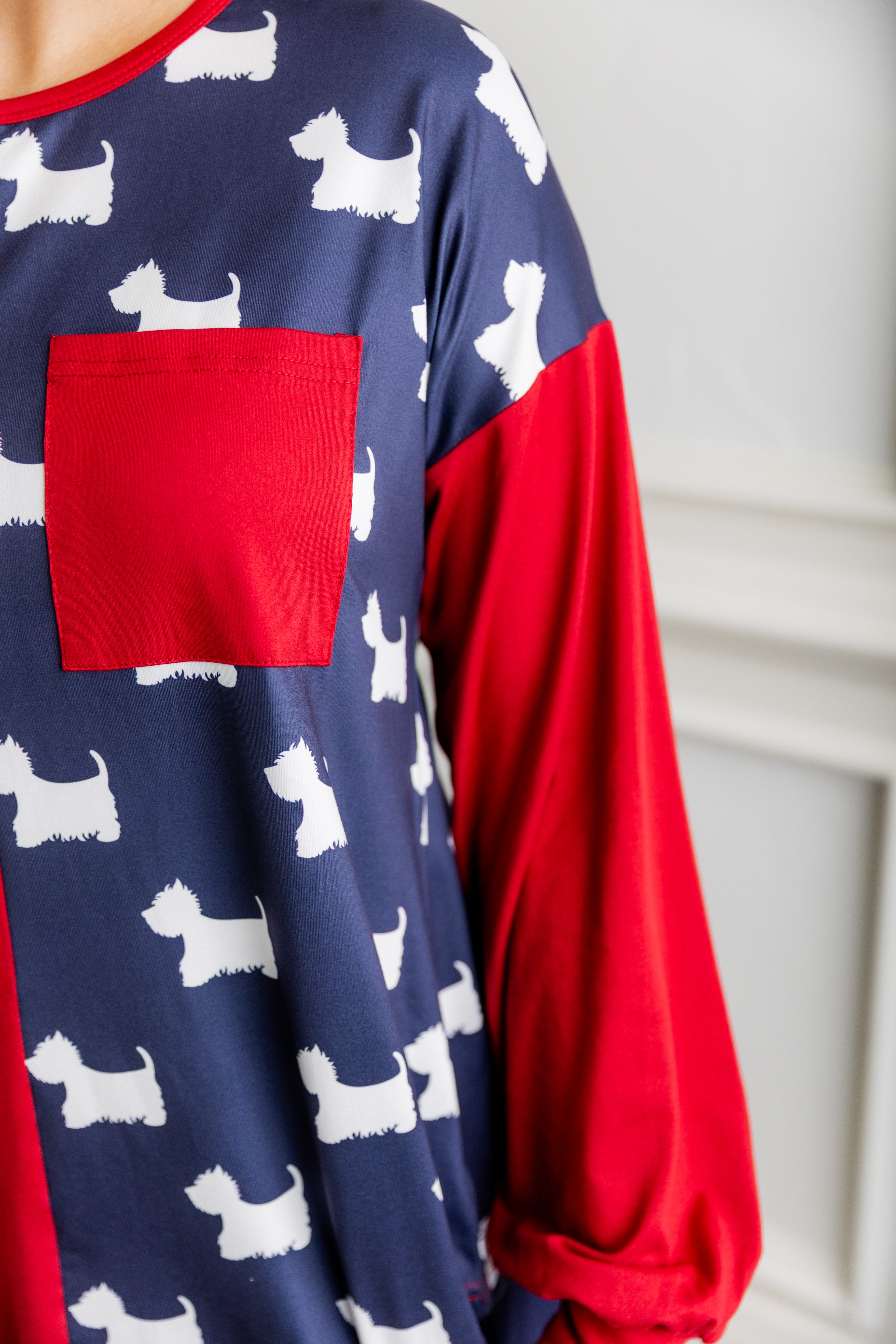 Model wearing the Nuggles® Harlow Top with red and navy color block design.