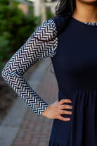 Modest sleeveless midi dress with tiered skirt and fitted bodice, styled for layering with a crew neckline – Hannah Layering Dress by Nuggles®.