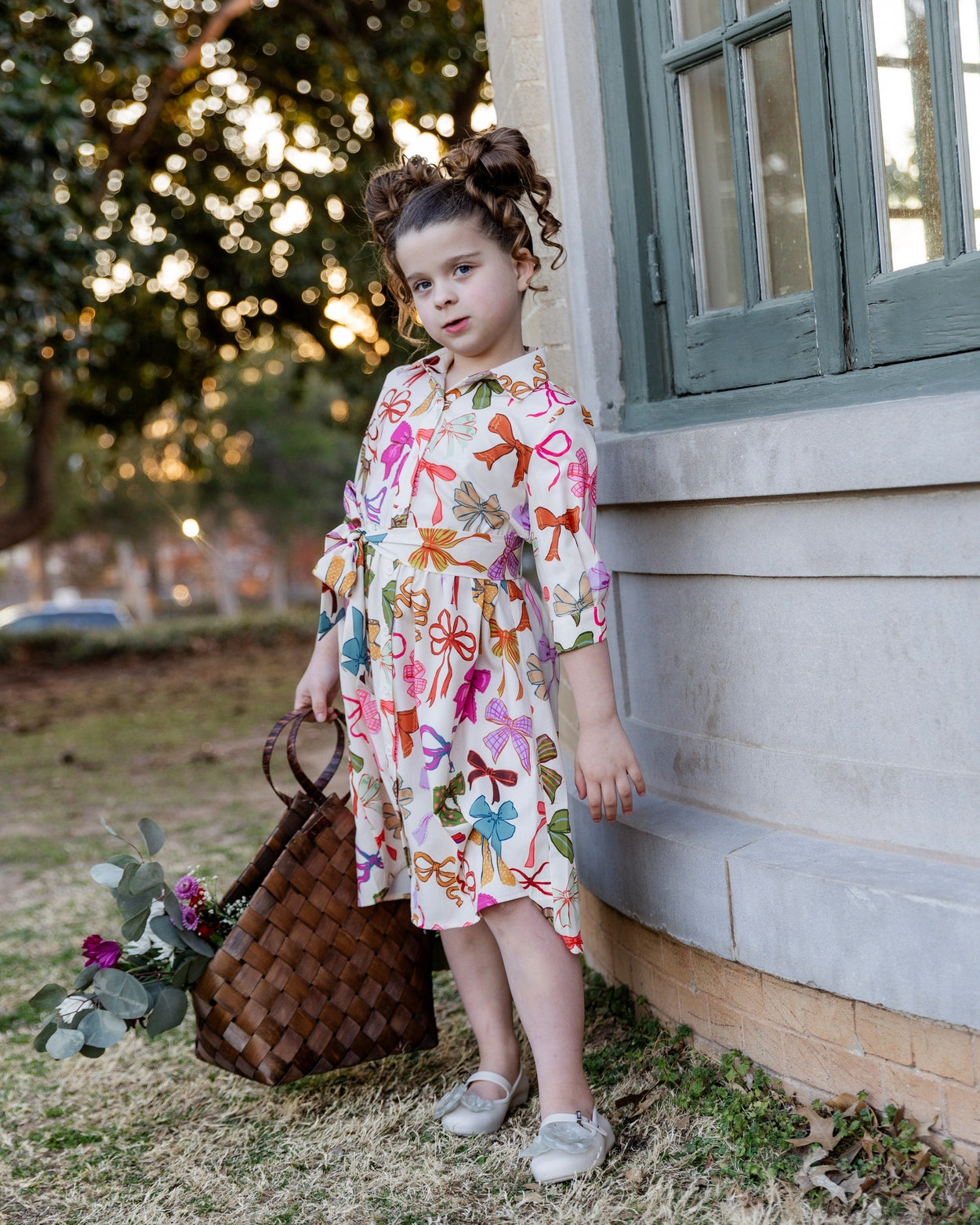 Model wearing the Nuggles® Girls' Rachel Dress in Bow Garden