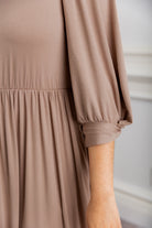 Modest Willow Solid Colors Dress by Nuggles® featuring a gathered waist, balloon sleeves, and side pockets; shown in various solid colors and angles for a stylish, comfortable everyday look.