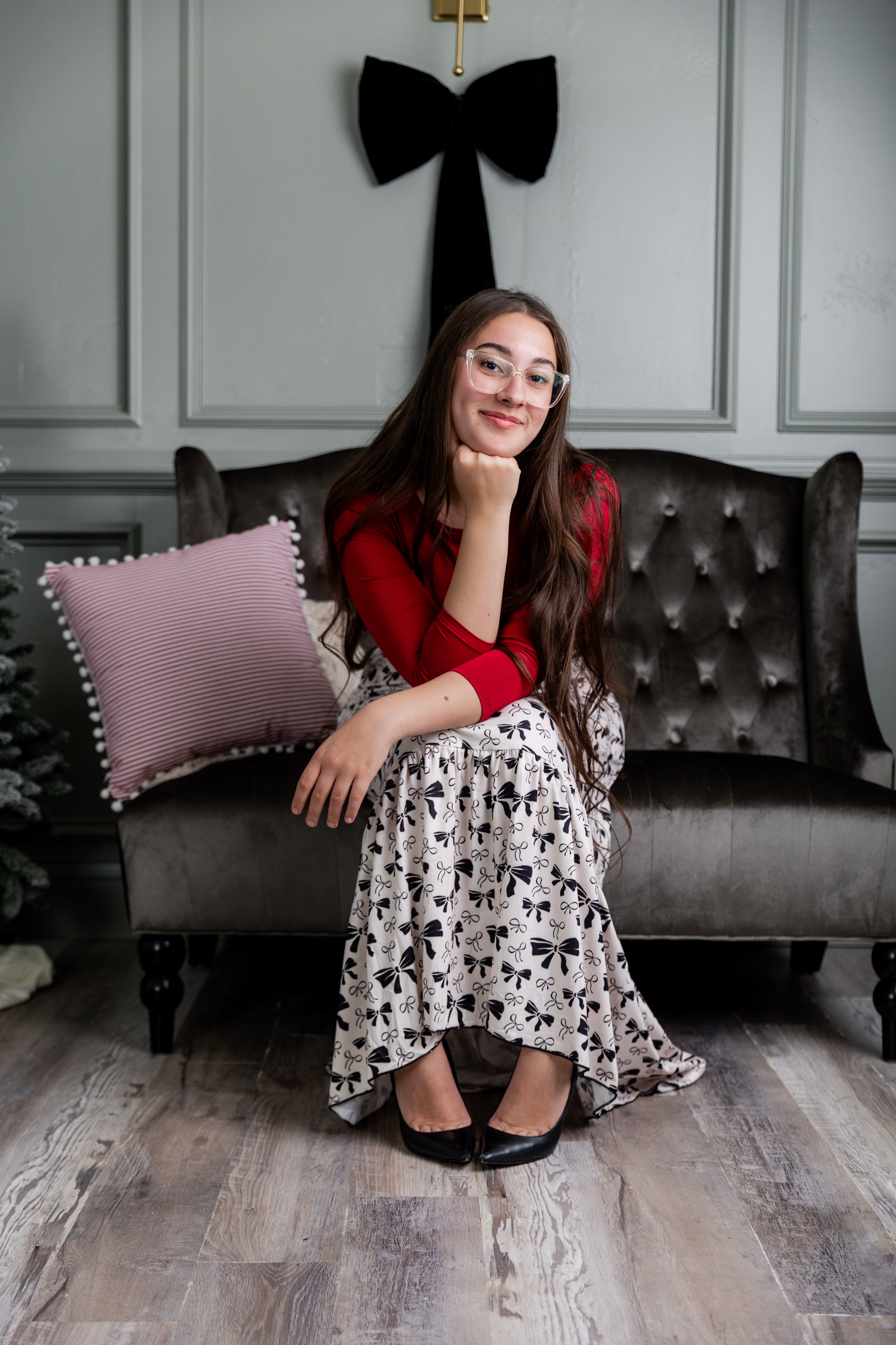 Model wearing the Nuggles® Sage Skirt in white with black bow print, featuring a gathered tiered hem and adjustable drawstring waist.