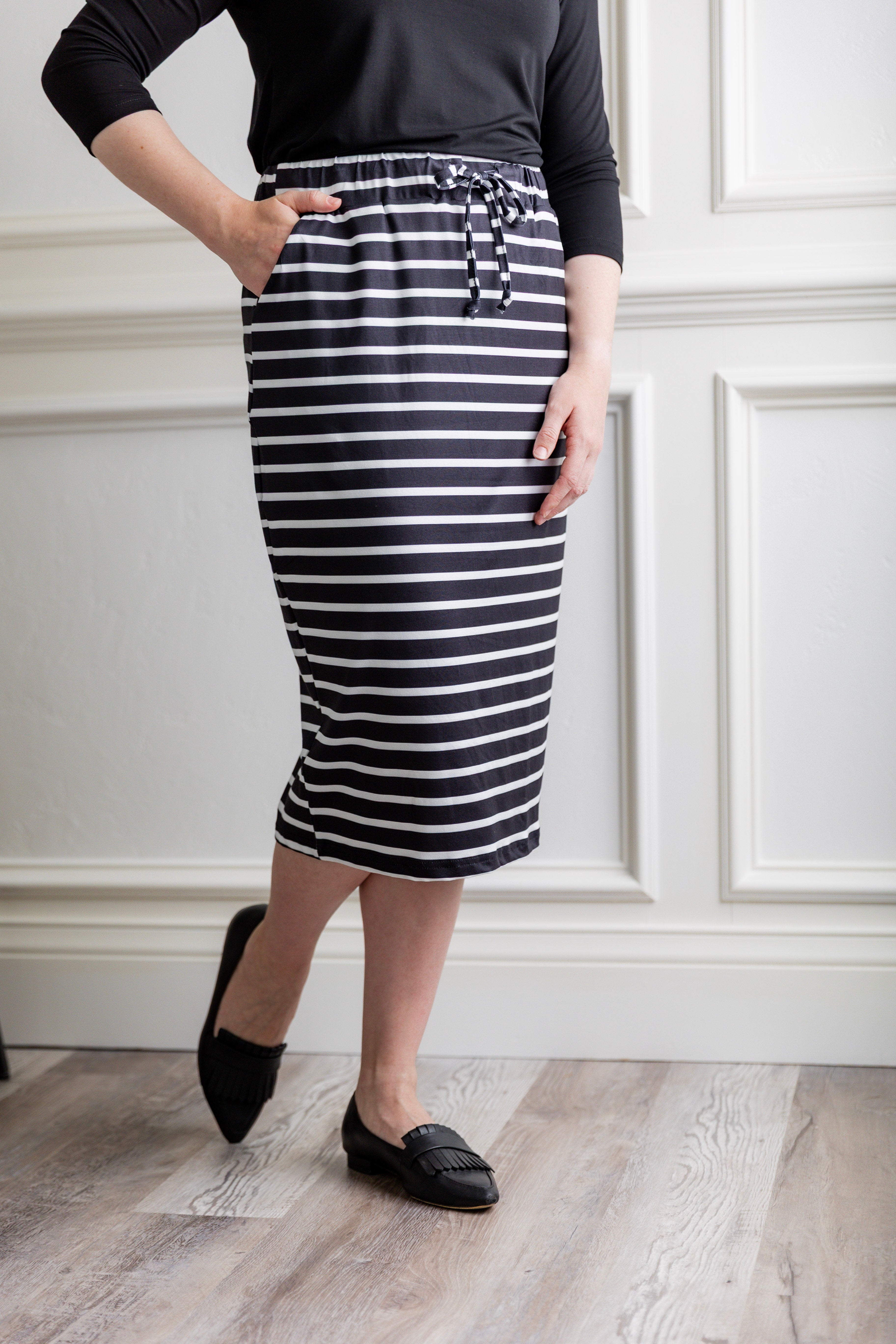 Woman wearing a modest 27-inch striped knit skirt in black and white with adjustable drawstring waistband.