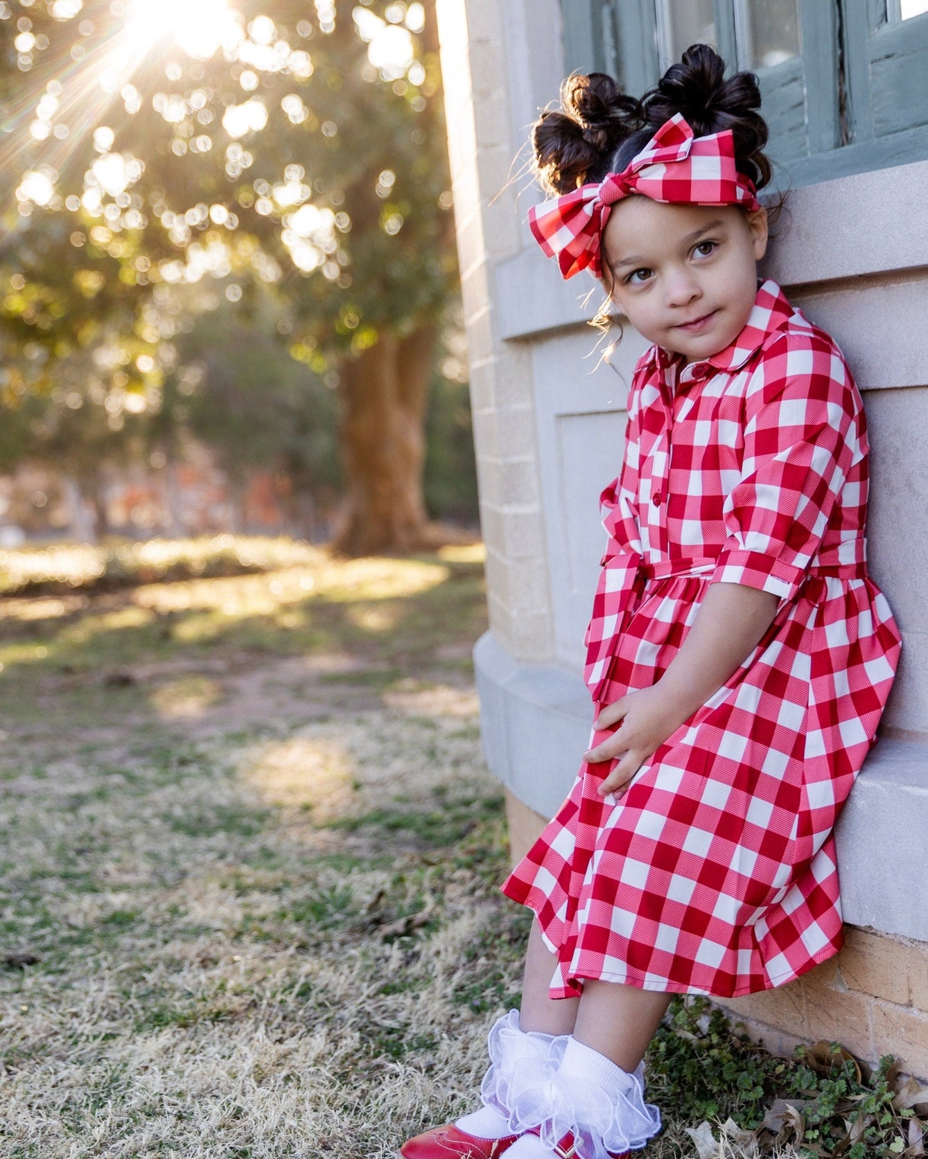Model wearing the Nuggles® Girls' Rachel Dress and matching Headband in Cherry Jam