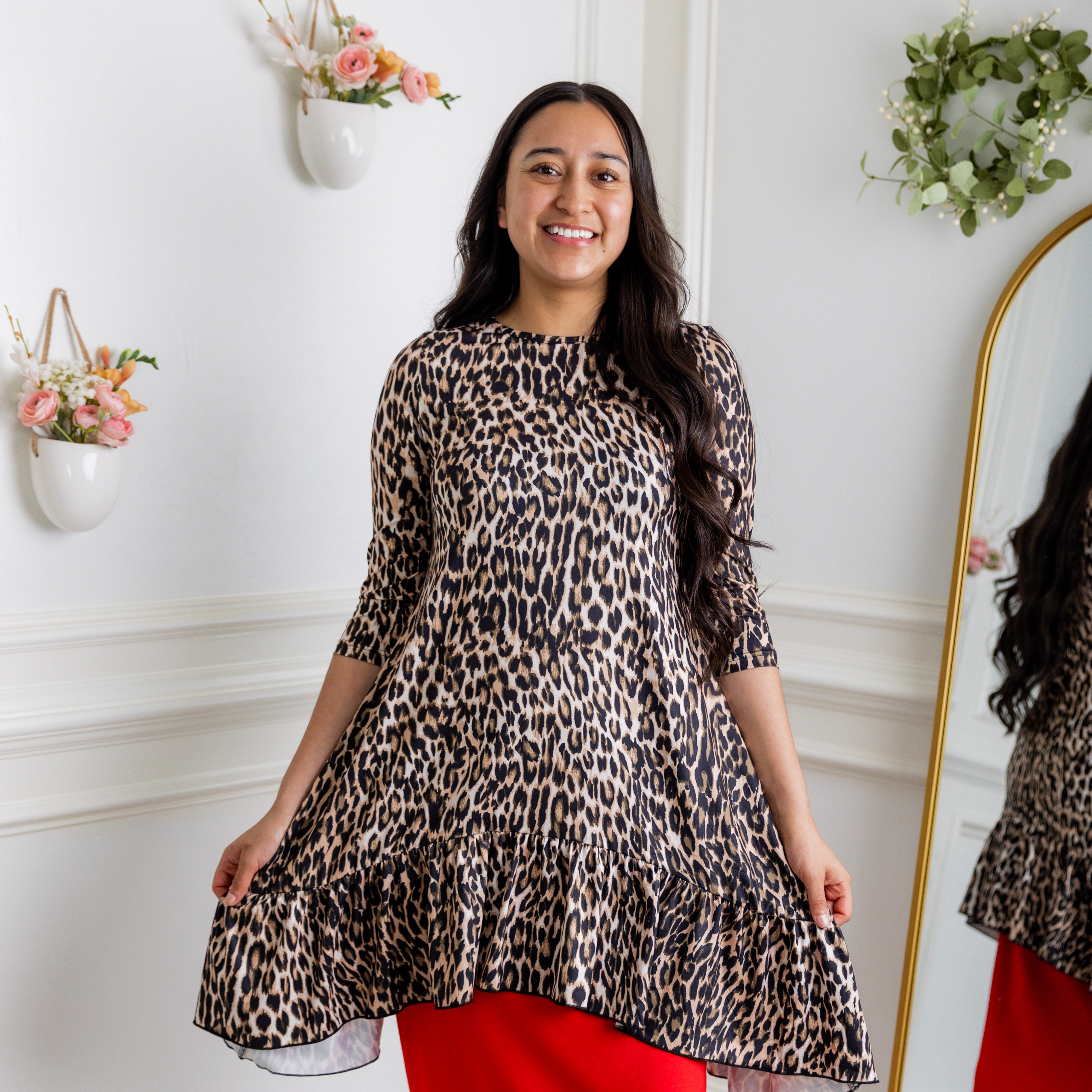 Leopard print modest tunic top for women – Nuggles® Rose Top with swing fit and ruffle hem, paired with red skirt.