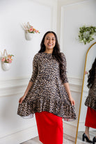 Leopard print modest tunic top for women – Nuggles® Rose Top with swing fit and ruffle hem, paired with red skirt.