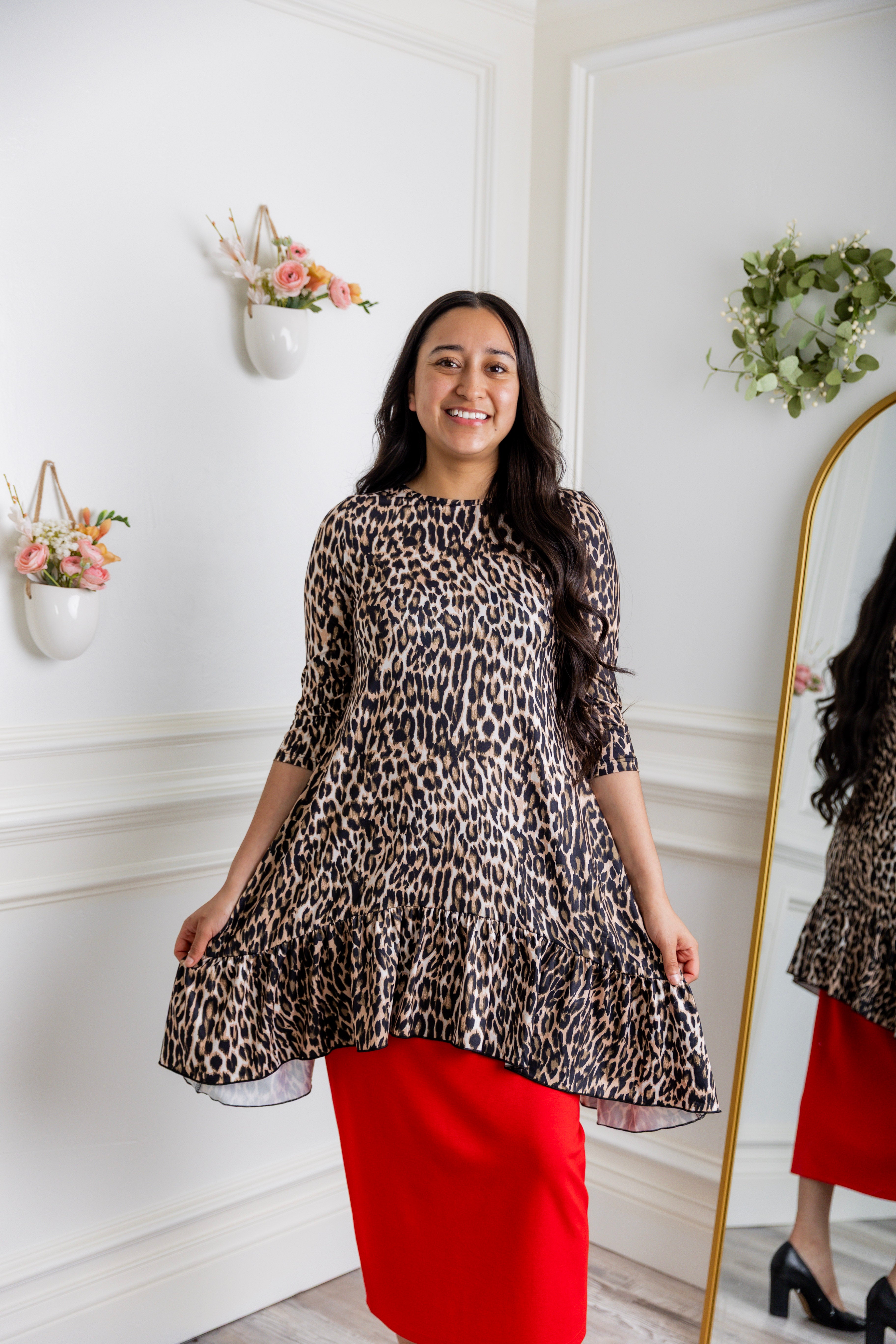 Leopard print modest tunic top for women – Nuggles® Rose Top with swing fit and ruffle hem, paired with red skirt.