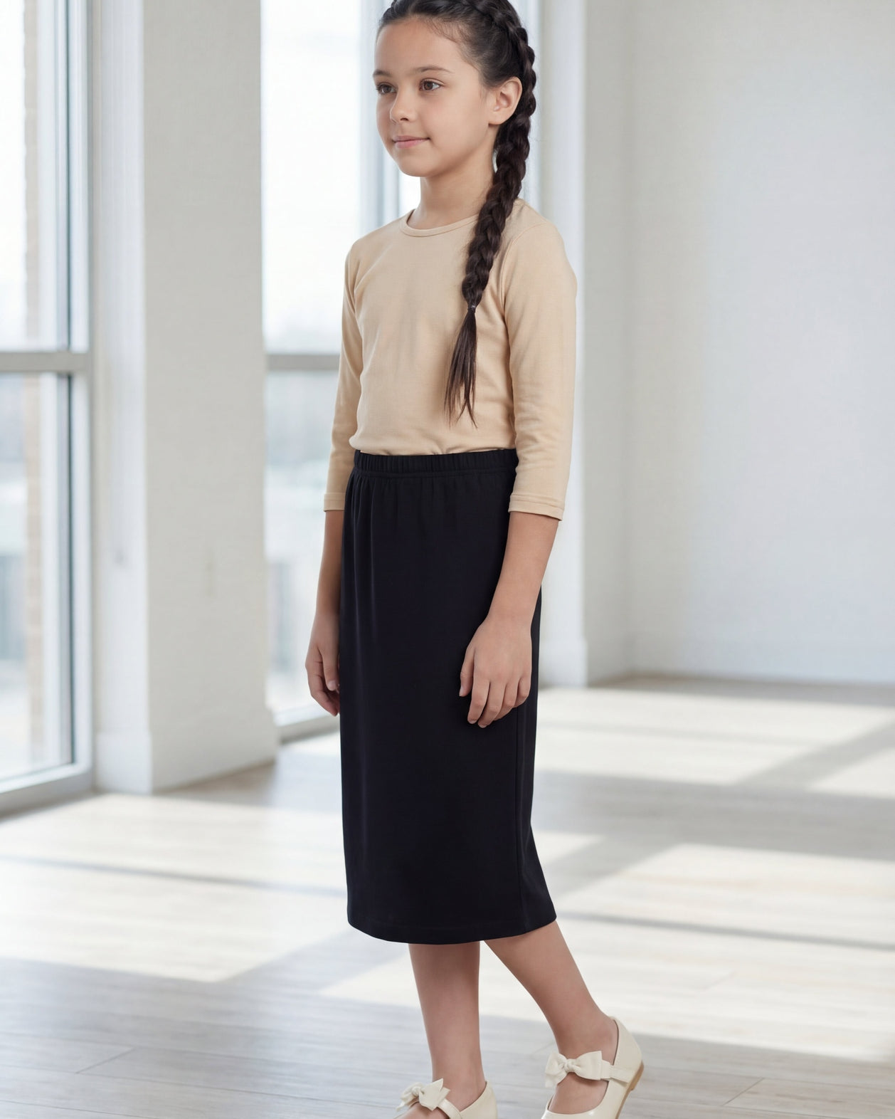 Model wearing the Nuggles® Girls' Classic Midi Skirt in Black
