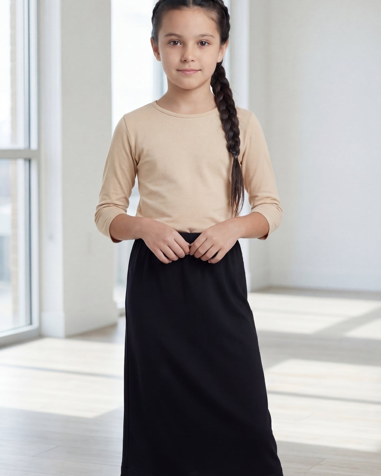 Model wearing the Nuggles® Girls' Classic Midi Skirt in Black