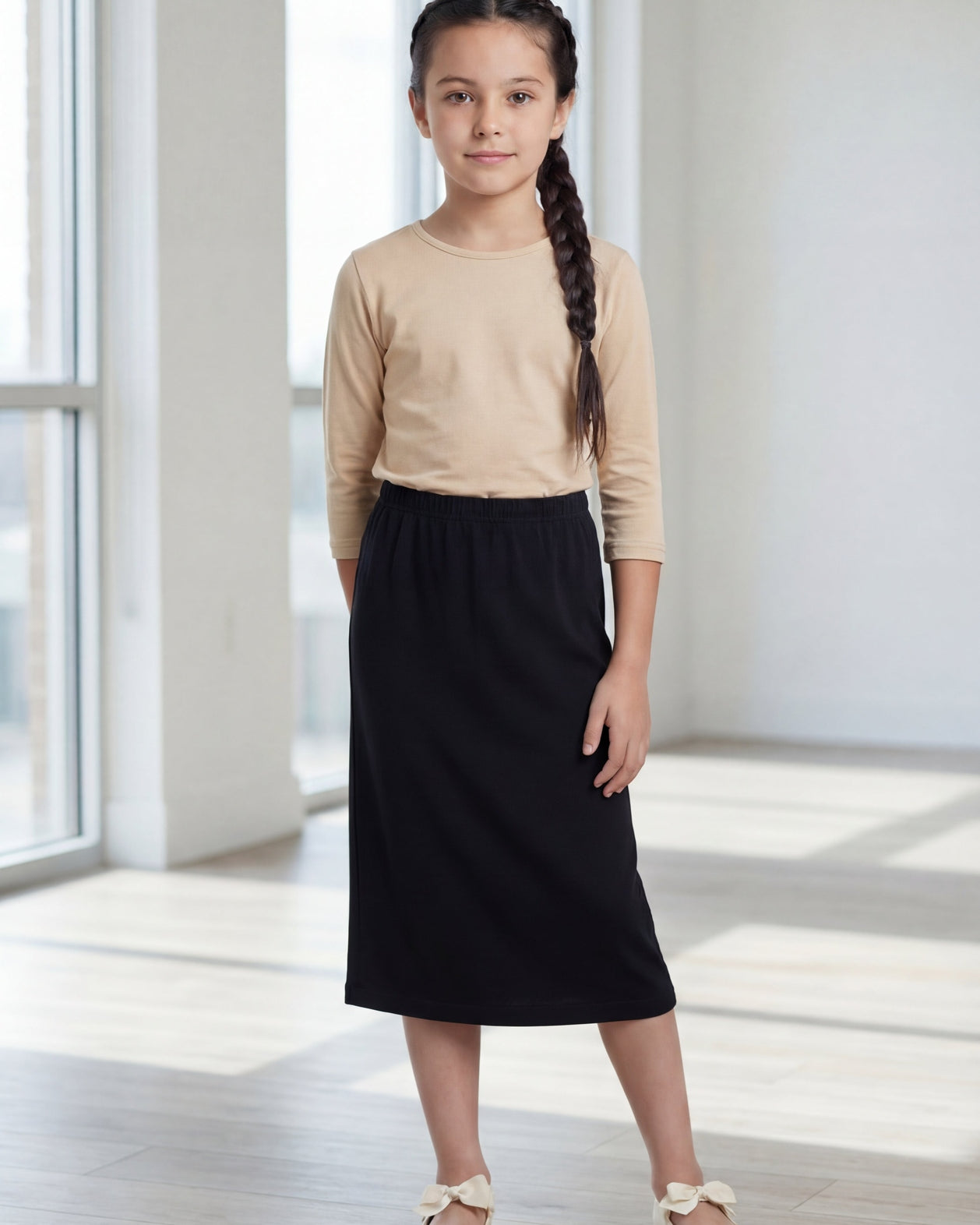 Model wearing the Nuggles® Girls' Classic Midi Skirt in Black