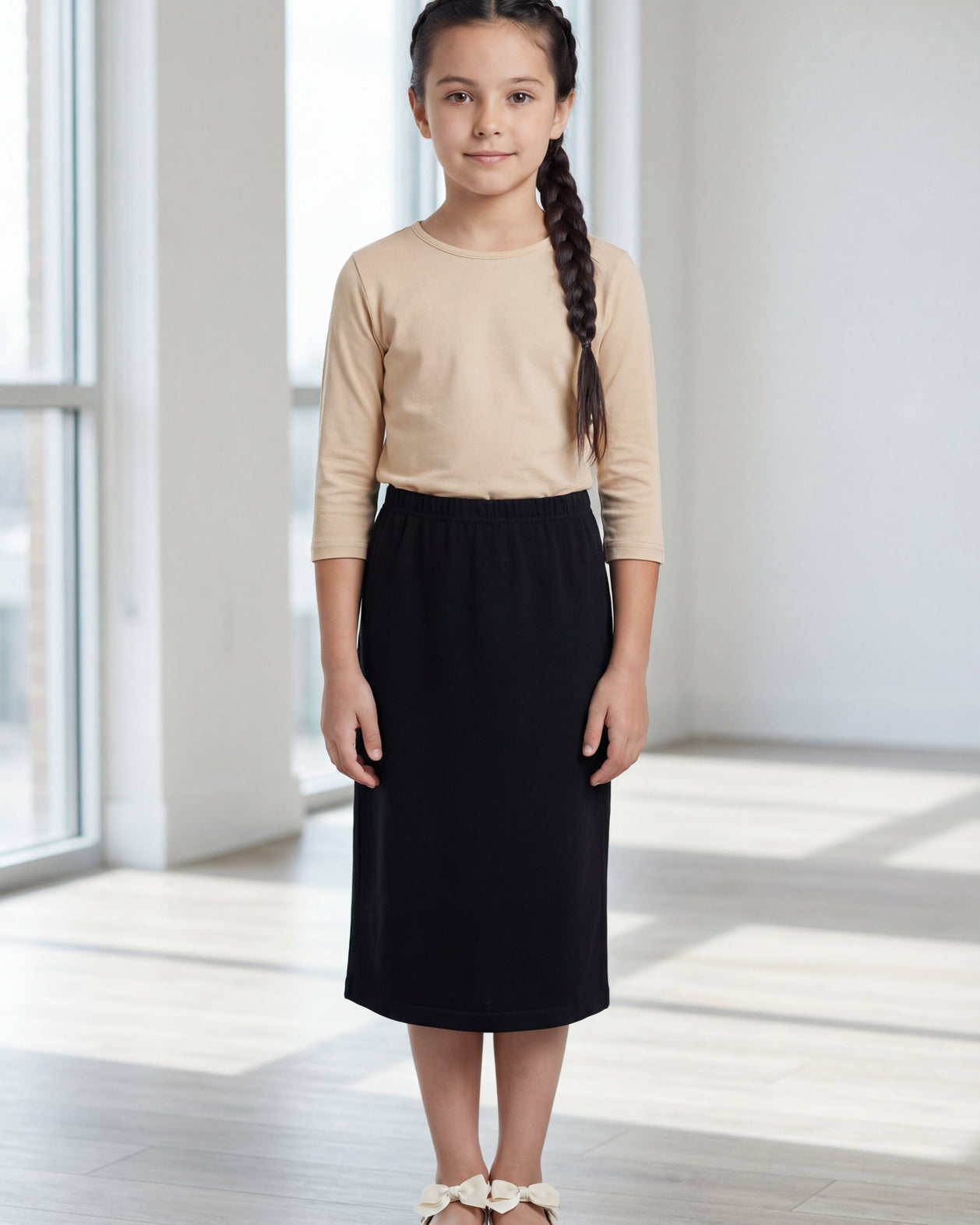 Model wearing the Nuggles® Girls' Classic Midi Skirt in Black
