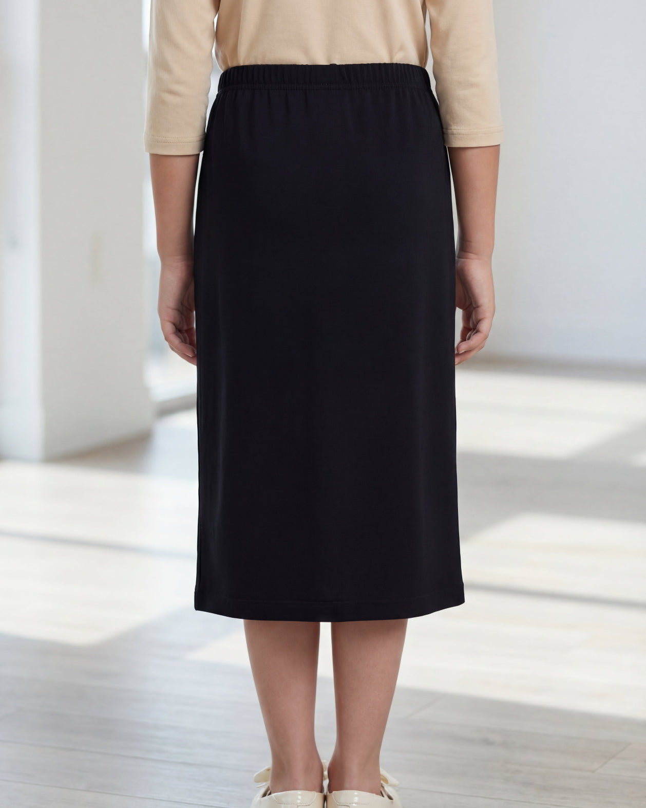 Model wearing the Nuggles® Girls' Classic Midi Skirt in Black