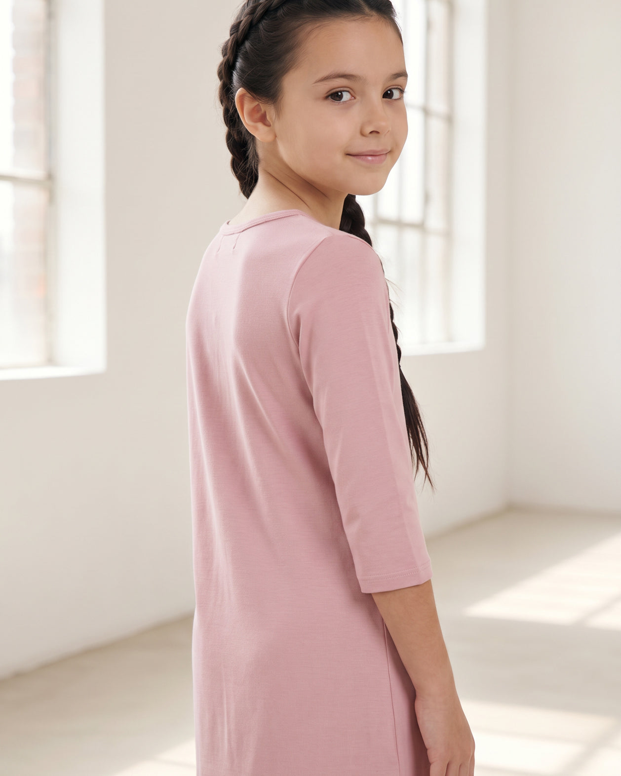 Model wearing Nuggles® Girls Layering Dress in Baby Pink