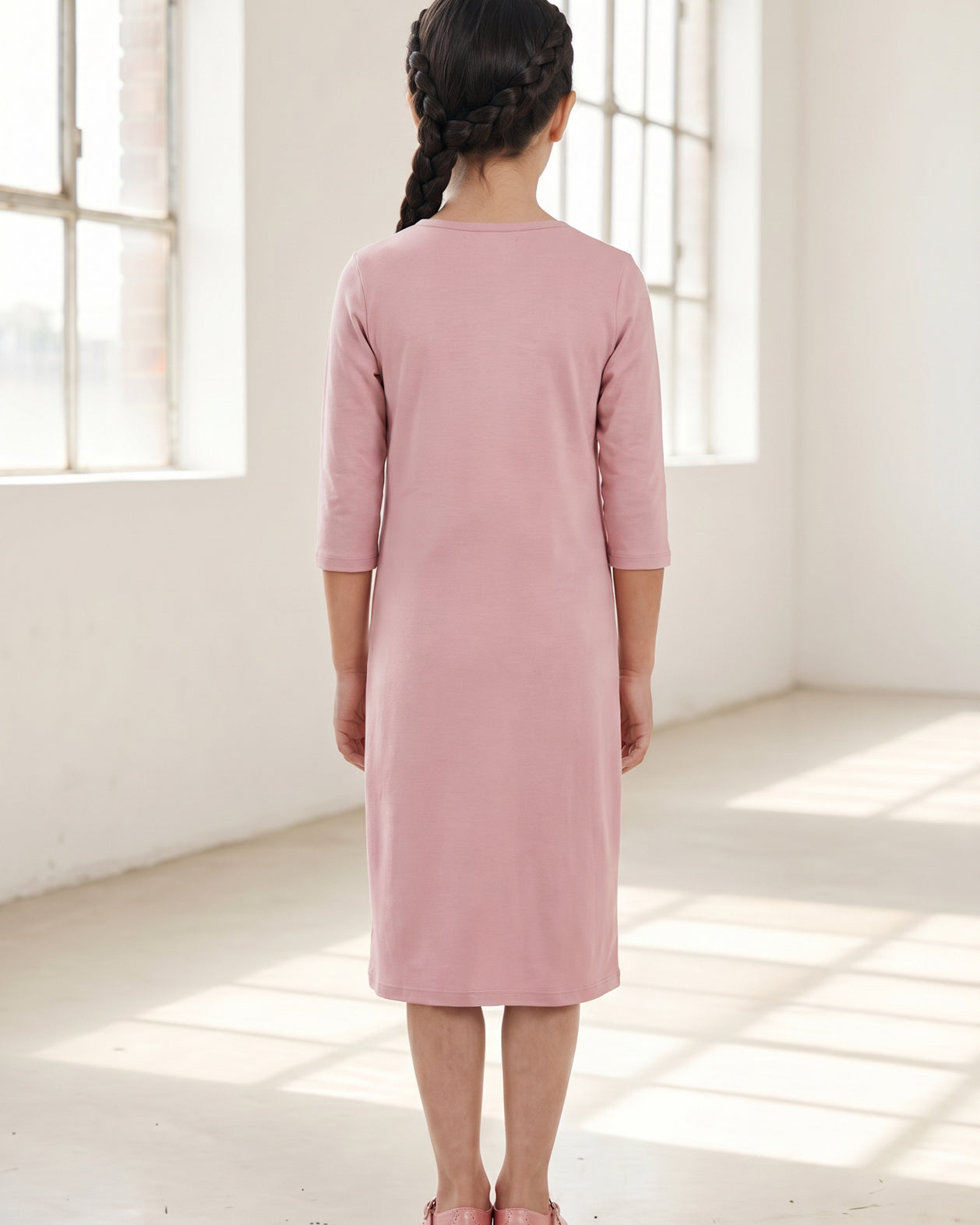 Model wearing Nuggles® Girls Layering Dress in Baby Pink