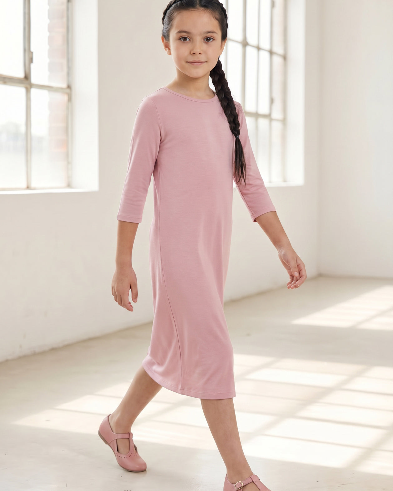 Model wearing Nuggles® Girls Layering Dress in Baby Pink