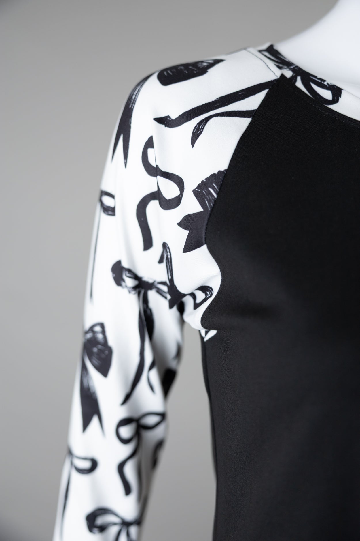 A close up picture of the black and white bow print on a 3/4 sleeve top.