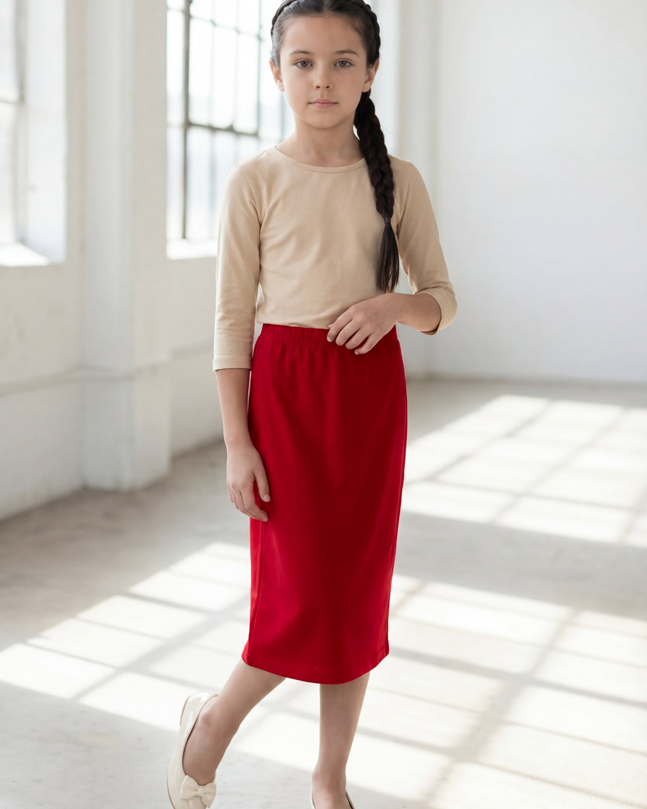 Model wearing the Nuggles® Girls' Classic Midi Skirt in Brick Red