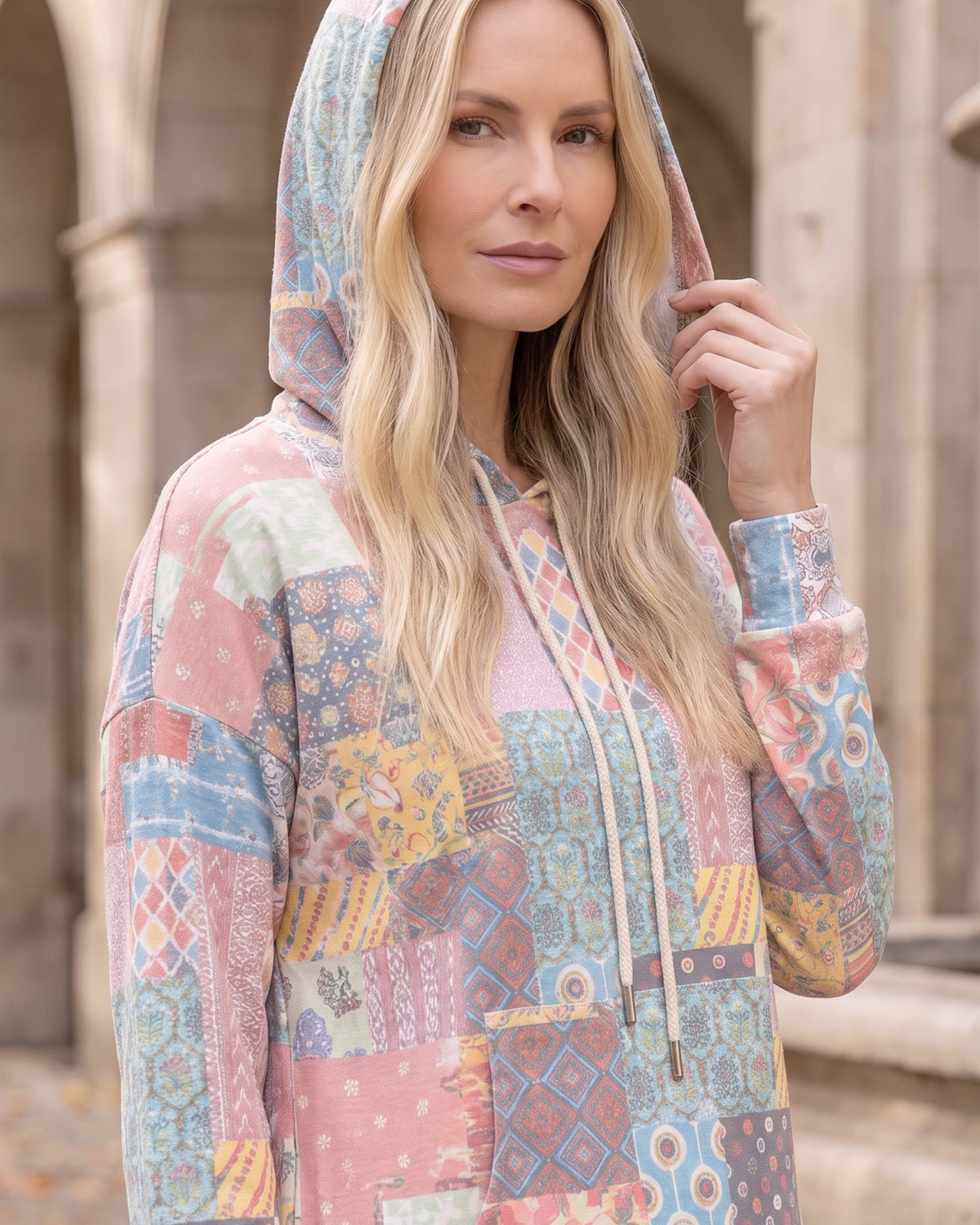 Nuggles® Hoodie Dress in Candy Lane worn with the hood up, showing the patchwork print scale
