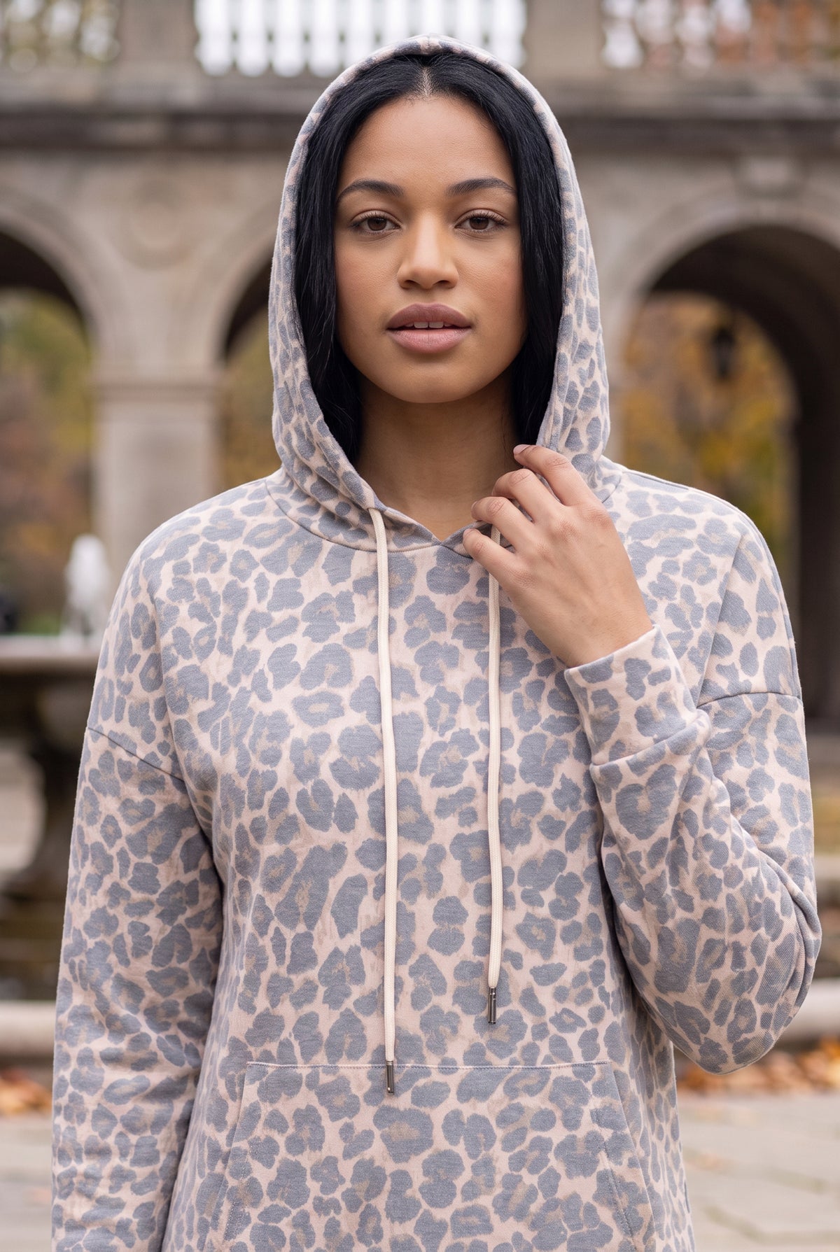 Nuggles® Hoodie Dress in Classic Leopard worn with the hood up, cream drawstring hanging loose