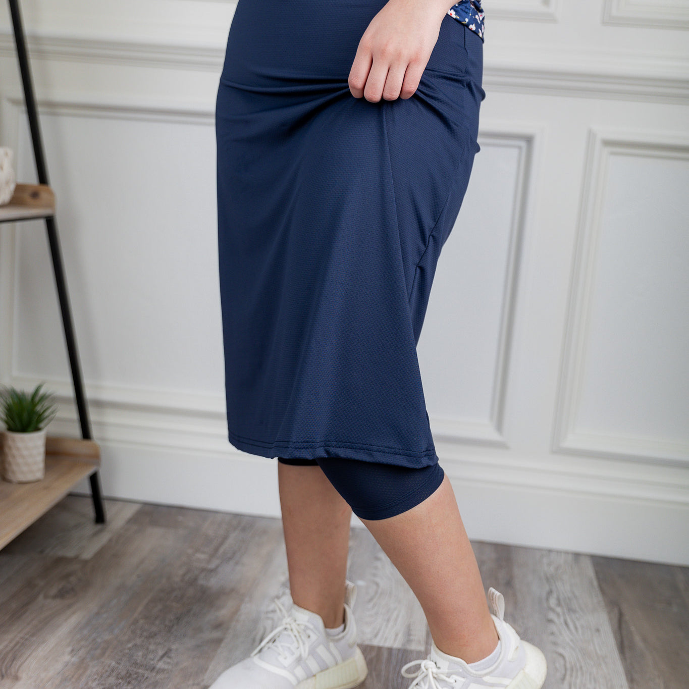 Woman wearing 27-inch navy modest sport skirt with built-in leggings—ideal for activewear, cycling, running, swimming, and workouts.