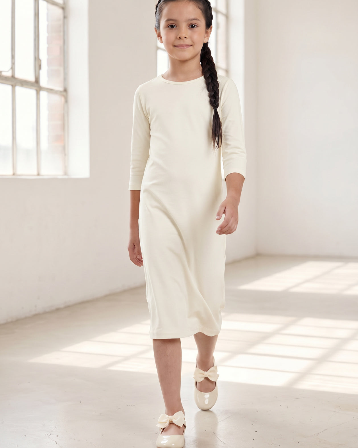 Model wearing Nuggles® Girls Midi Layering Dress in Cream