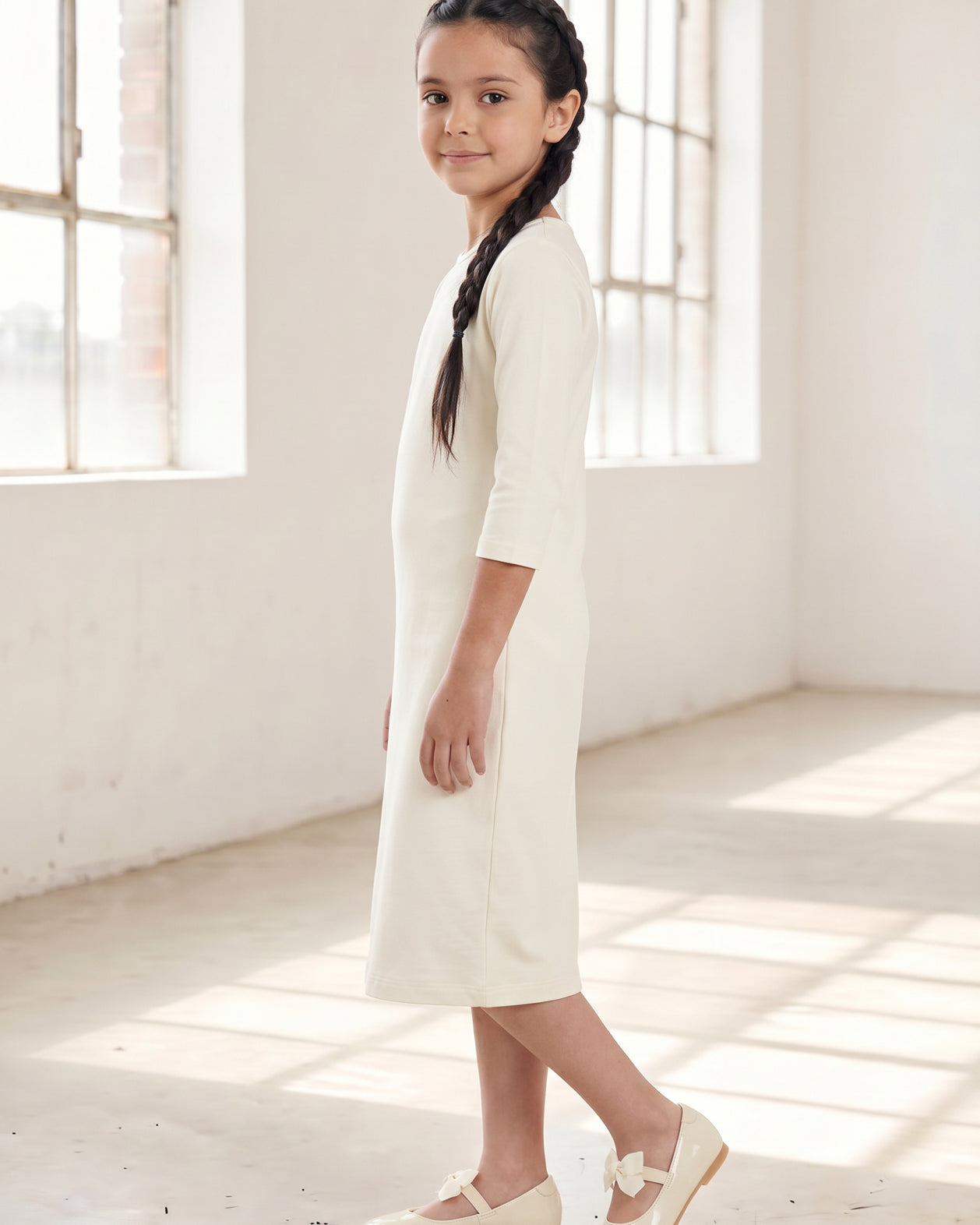 Model wearing Nuggles® Girls Midi Layering Dress in Cream