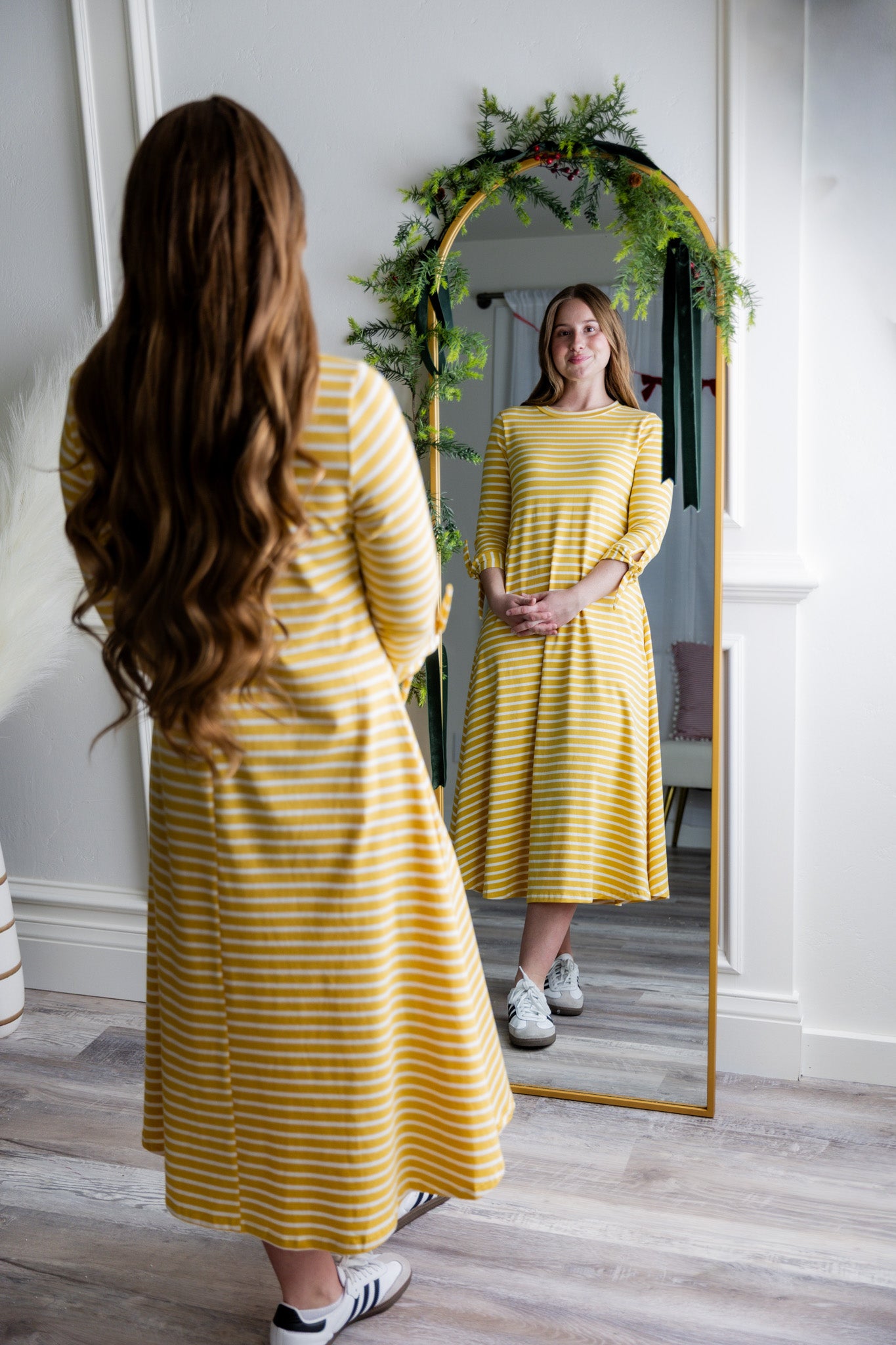 Model wearing the Nuggles® Gracie Dress, a modest A-line midi dress with ¾ sleeves and tie accents, made from soft knit fabric.