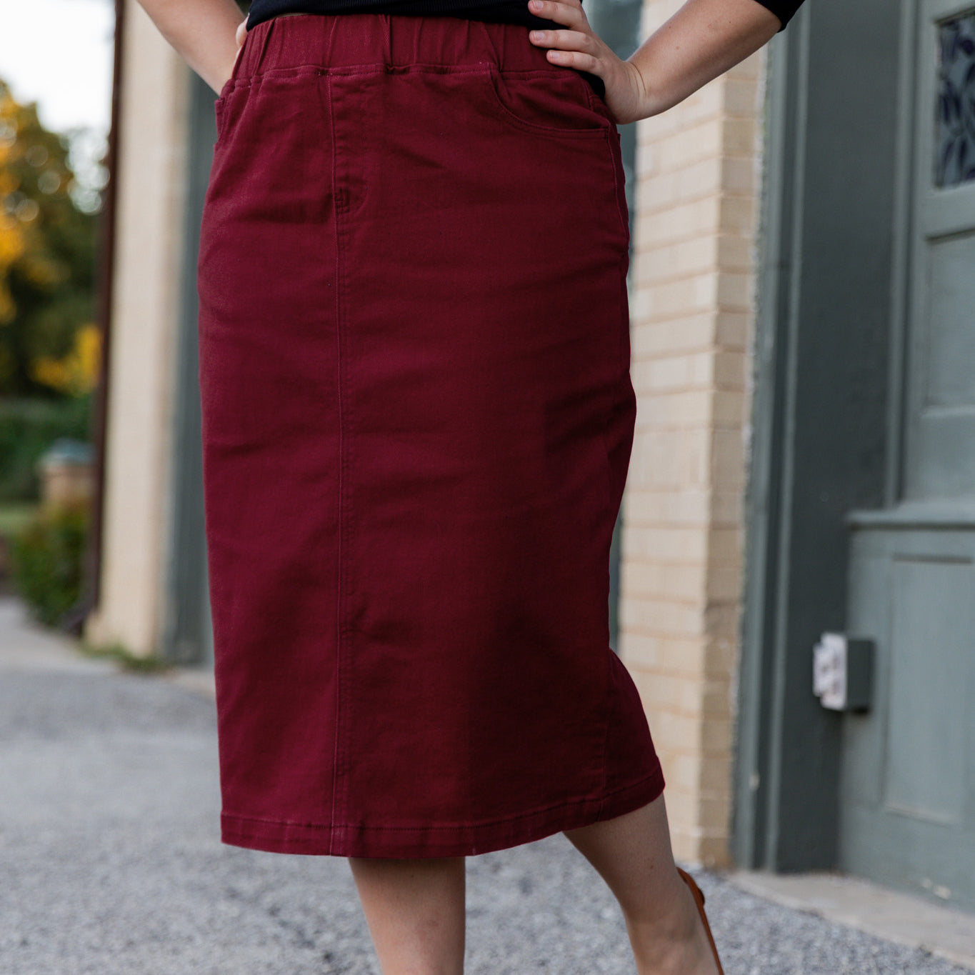 Nuggles® denim midi skirt with soft stretch fabric, wide elastic waistband, modest length, and functional pockets. Available in 27", 31", and 34" lengths.