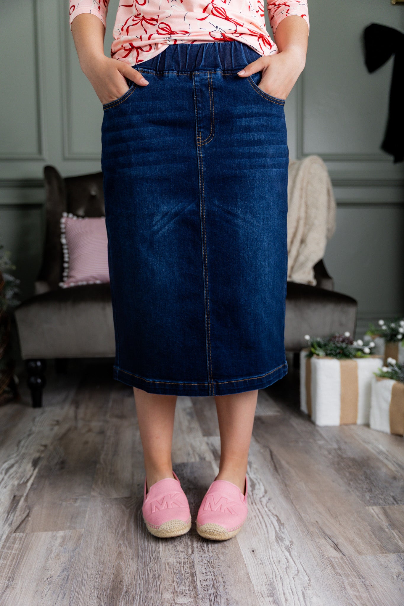 Nuggles® denim midi skirt with soft stretch fabric, wide elastic waistband, modest length, and functional pockets. Available in 27", 31", and 34" lengths.