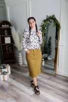 Nuggles® denim midi skirt with soft stretch fabric, wide elastic waistband, modest length, and functional pockets. Available in 27", 31", and 34" lengths.