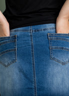 Nuggles® denim midi skirt with soft stretch fabric, wide elastic waistband, modest length, and functional pockets. Available in 27", 31", and 34" lengths.