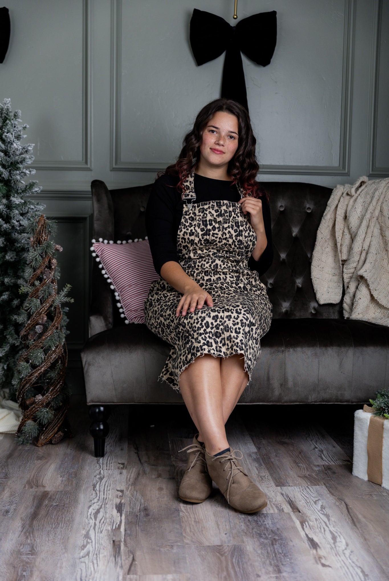 Model wearing a 'NUGGLES® modest leopard denim overall dress with front pocket and raw hem.