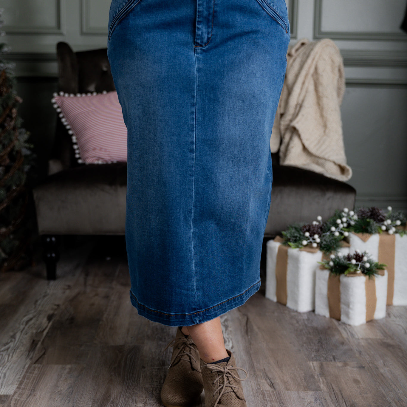 Nuggles® denim midi skirt with soft stretch fabric, wide elastic waistband, modest length, and functional pockets. Available in 27", 31", and 34" lengths.