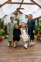 Young girl wearing Nuggles® Zoelle Dress in solid color, modest hoodie dress with puff sleeves.