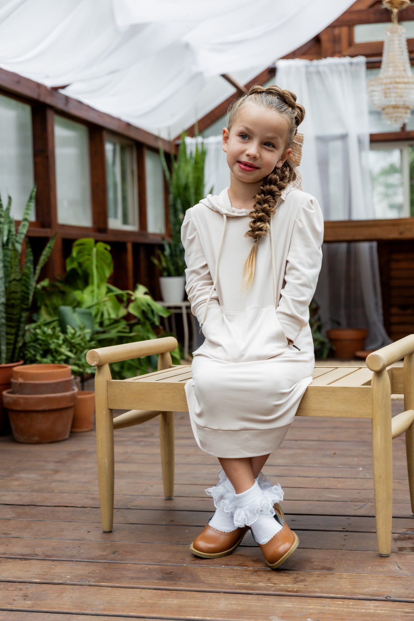 Young girl wearing Nuggles® Zoelle Dress in solid color, modest hoodie dress with puff sleeves.