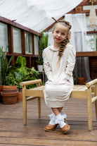 Young girl wearing Nuggles® Zoelle Dress in solid color, modest hoodie dress with puff sleeves.