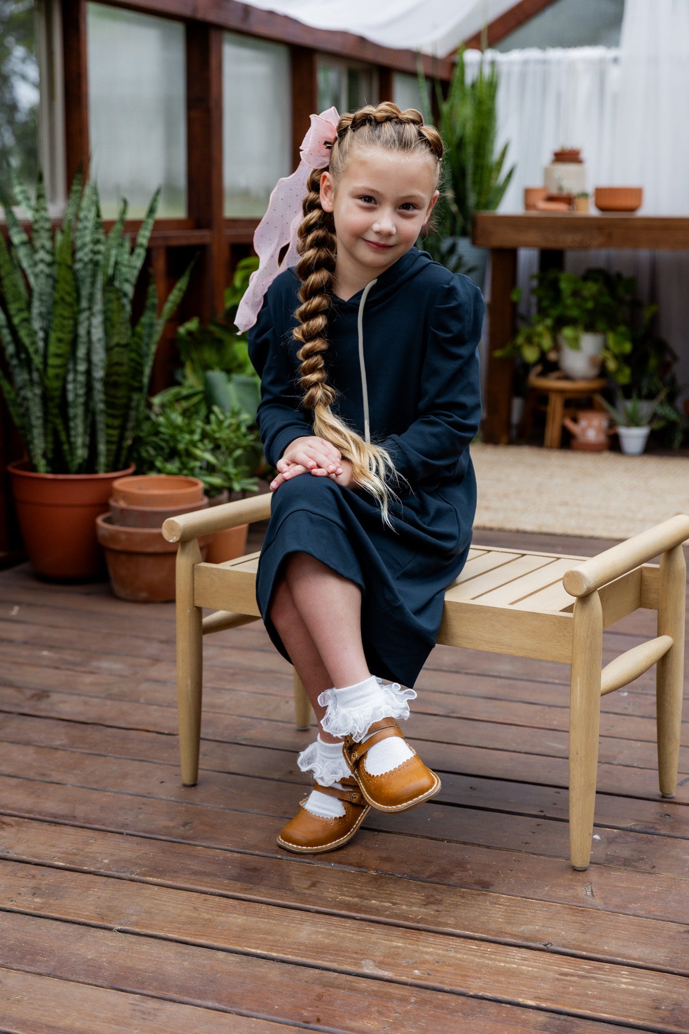 Young girl wearing Nuggles® Zoelle Dress in solid color, modest hoodie dress with puff sleeves.