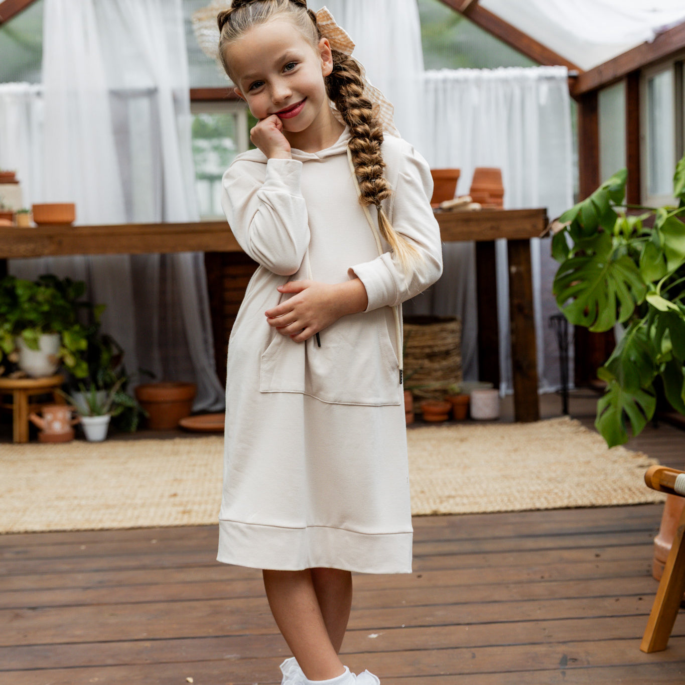 Young girl wearing Nuggles® Zoelle Dress in solid color, modest hoodie dress with puff sleeves.