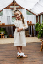 Young girl wearing Nuggles® Zoelle Dress in solid color, modest hoodie dress with puff sleeves.