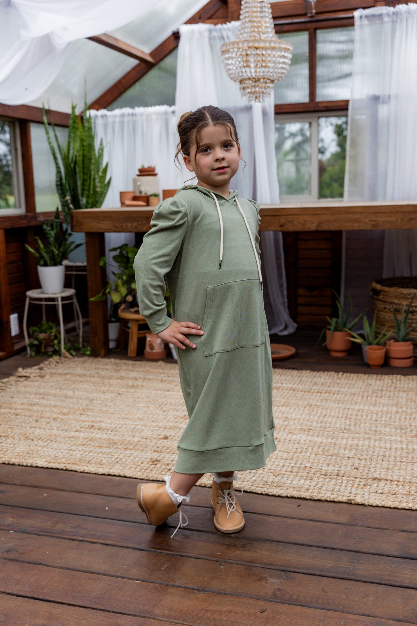 Young girl wearing Nuggles® Zoelle Dress in solid color, modest hoodie dress with puff sleeves.