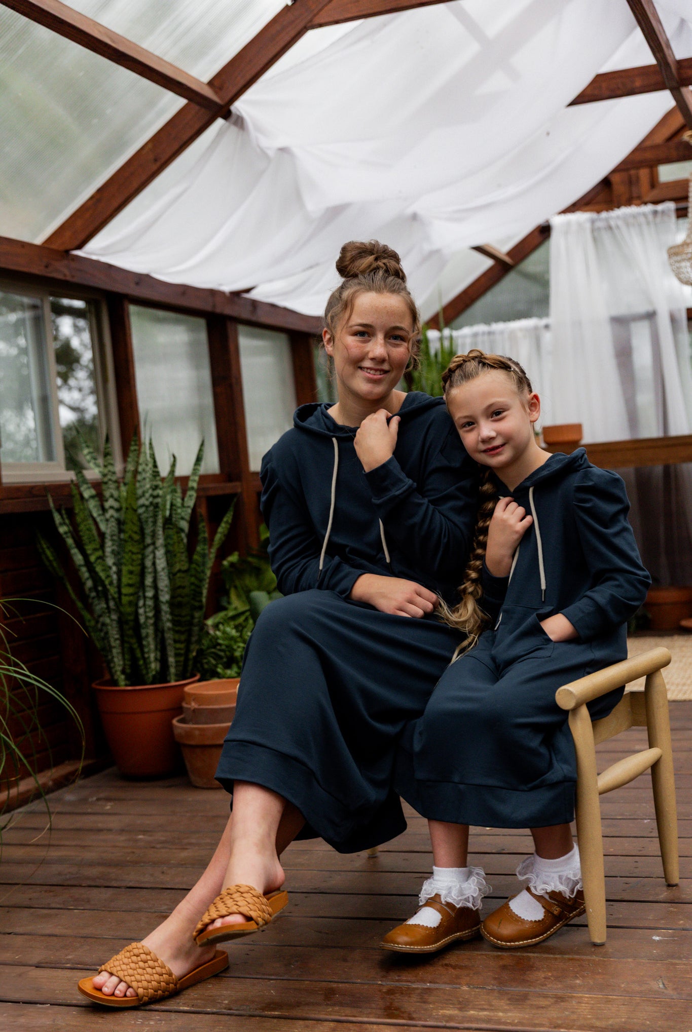 Model wearing Nuggles® Zoelle Dress in solid color, modest hoodie dress with puff sleeves.