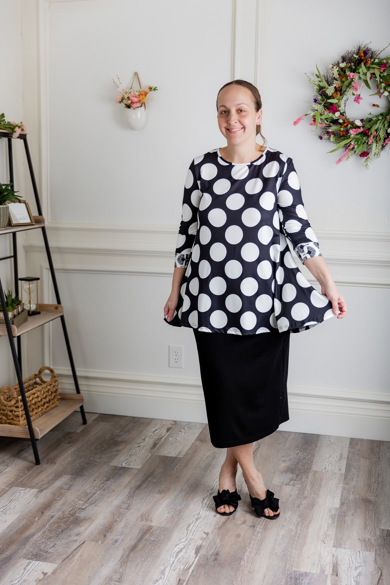 Model wearing the 3/4 Sleeve Victoria Top in floral print, paired with a modest Classic skirt. Modest women’s fashion with 3/4 sleeves and hip-length fit, perfect for church, work, or everyday wear.