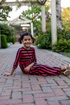 Young girl wearing the Nuggles® Girls Adelia Dress — a modest striped maxi dress with bow tie waist.