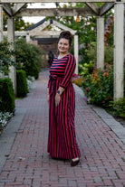 Model wearing the Nuggles® Adelia Dress, a modest striped maxi dress with waist tie and ¾ sleeves.