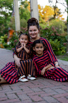 Young girl wearing the Nuggles® Girls Adelia Dress — a modest striped maxi dress with bow tie waist.