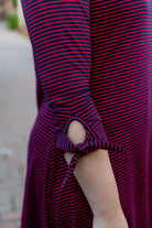 Model wearing the Nuggles® Gracie Dress, a modest A-line midi dress with ¾ sleeves and tie accents, made from soft knit fabric.