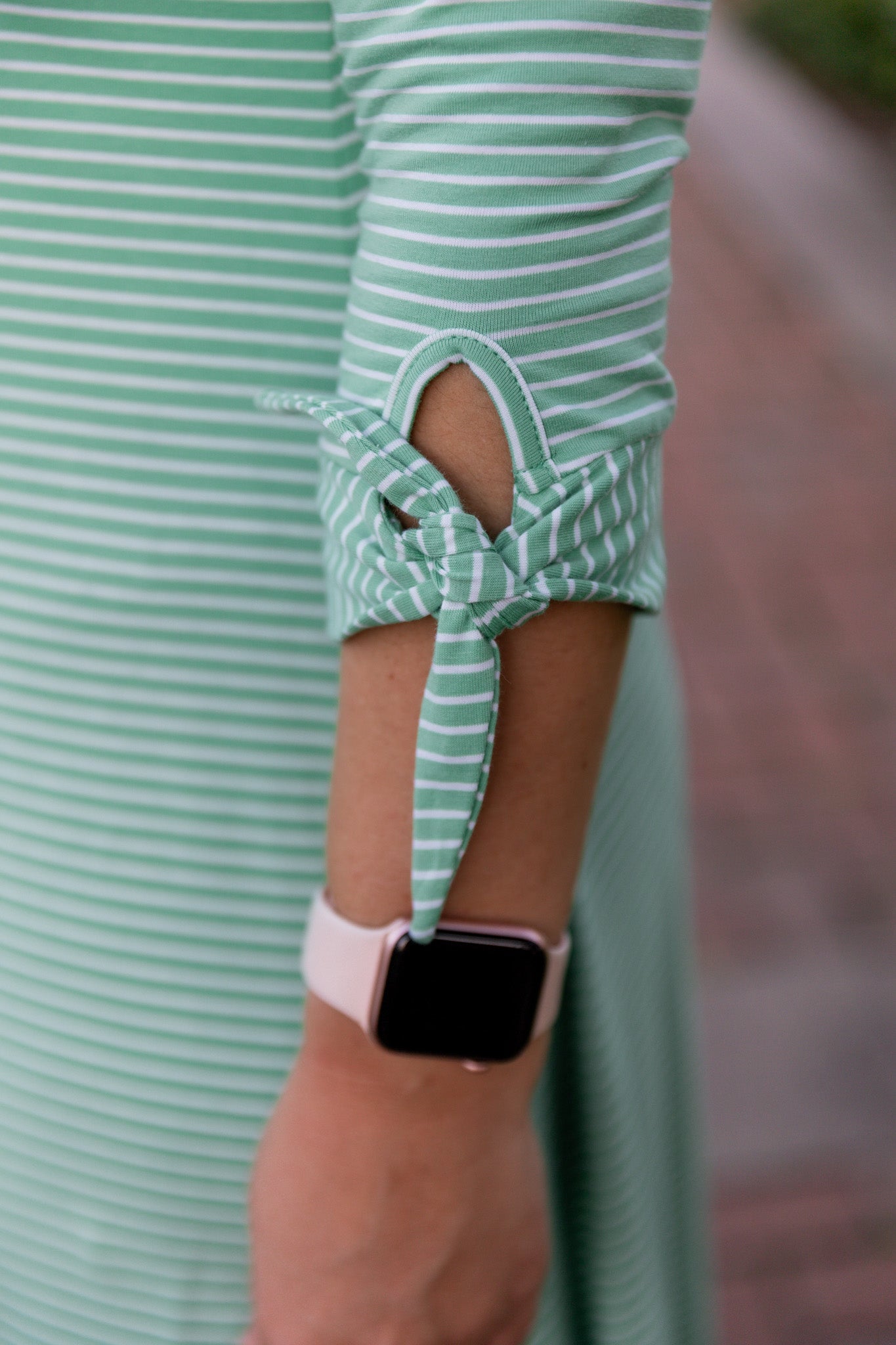 Model wearing the Nuggles® Gracie Dress, a modest A-line midi dress with ¾ sleeves and tie accents, made from soft knit fabric.