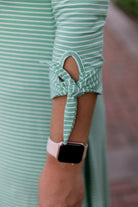 Model wearing the Nuggles® Gracie Dress, a modest A-line midi dress with ¾ sleeves and tie accents, made from soft knit fabric.